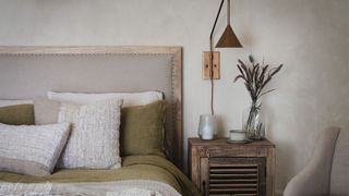neutral bedroom with bedside table and wall lamp