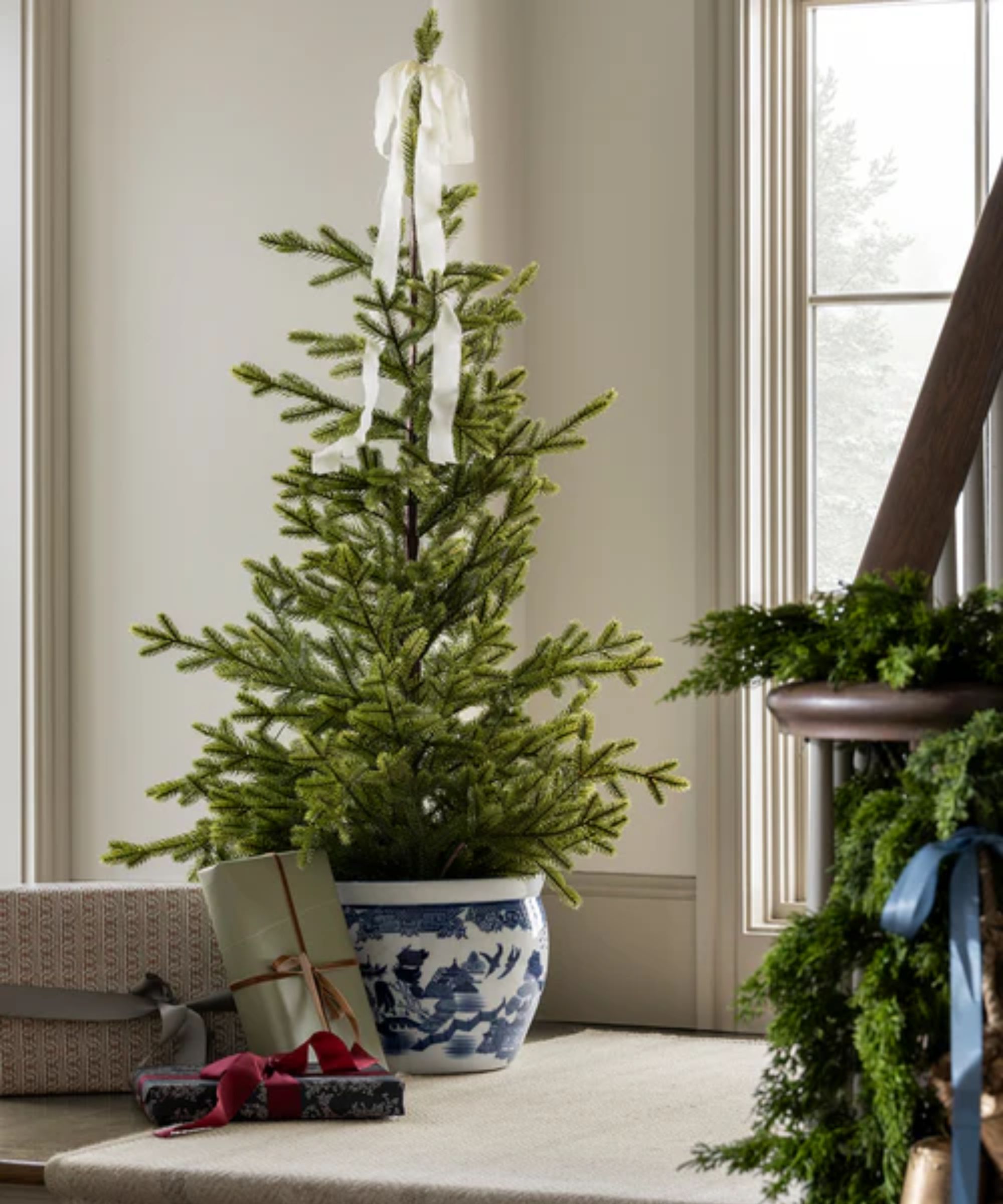 mcgee &amp;amp; co christmas tree styled in a chinoiserie pot with a white ribbon and wrapped gifts below
