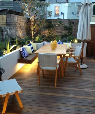 A decked backyard with lit built-in planters