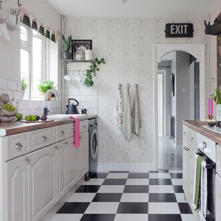 kitchen with black and white tiles and white cabinet with wooden flooring