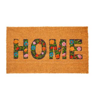 A brown welcome mat that says 'home' with floral patterned lettering
