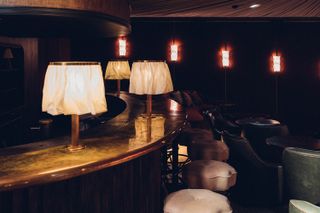 A dark bar area with frilled lamps