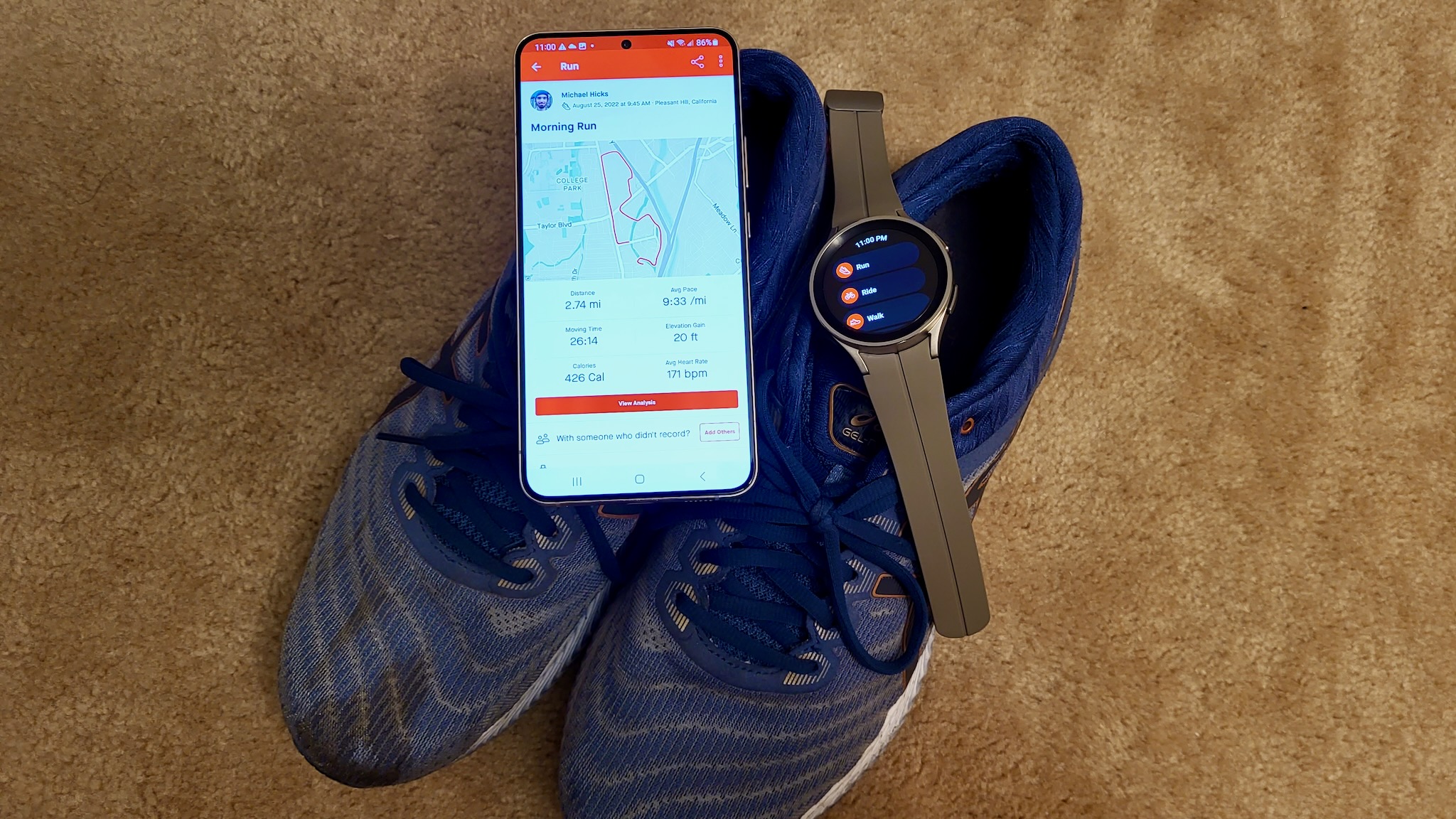 The Strava app on the Galaxy S22 Plus and Galaxy Watch 5 Pro, both on top of a pair of running shoes