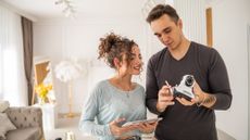 Man and woman setting up home security camera