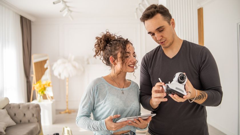 Man and woman setting up home security camera