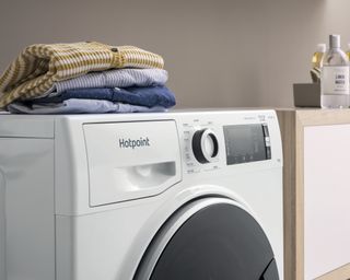 A washing machine with pile of laundry on top