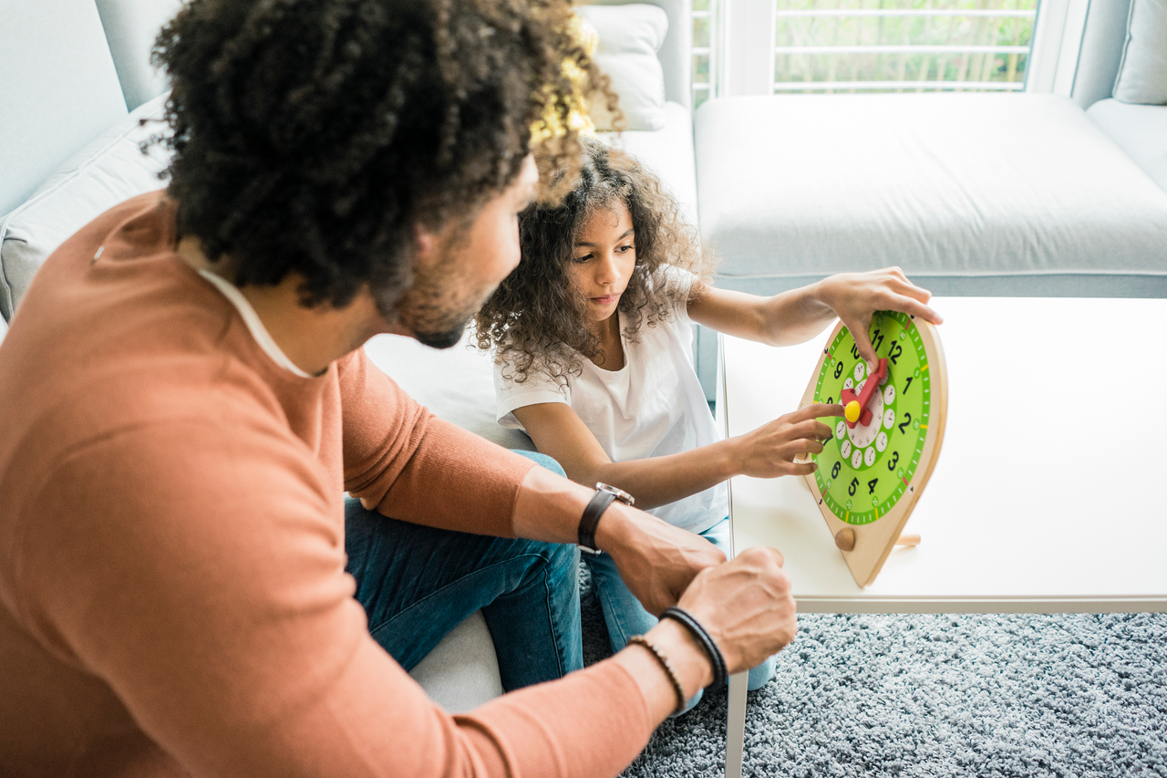 father teaching daughter to tell the time