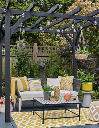 garden area with gazebo and lighting cord and sofa with cushions