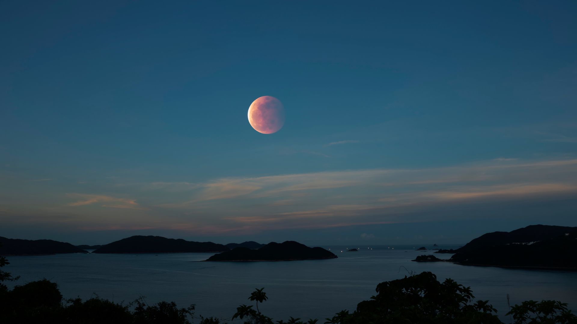 A Blood Moon full moon rises in the sky over Hong Kong