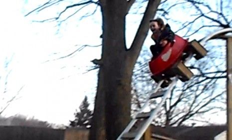 Samual Cain looks utterly delighted as he takes a 12-foot plunge on the roller coaster his parents built for him and his sister in their backyard.