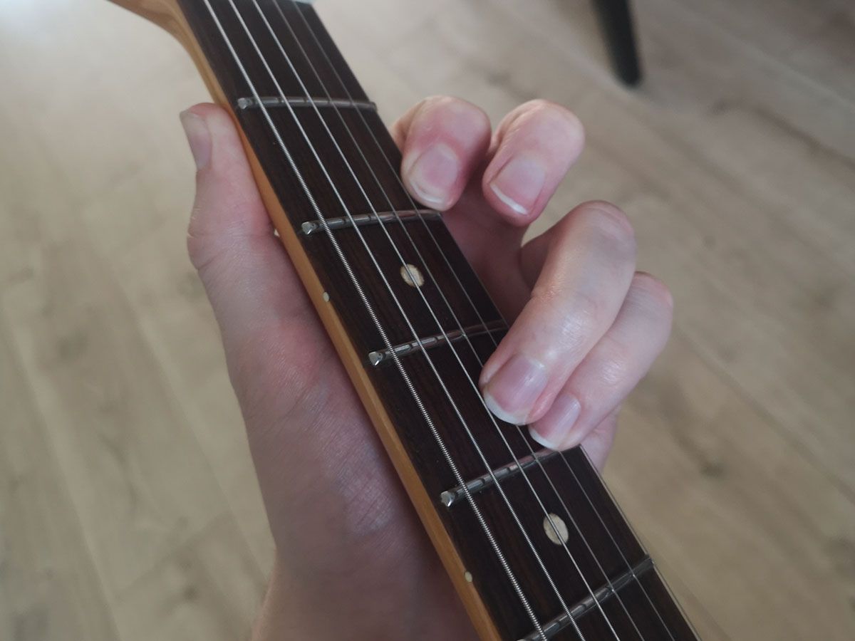 A demonstration of how to play a part of a B major barre chord on three strings