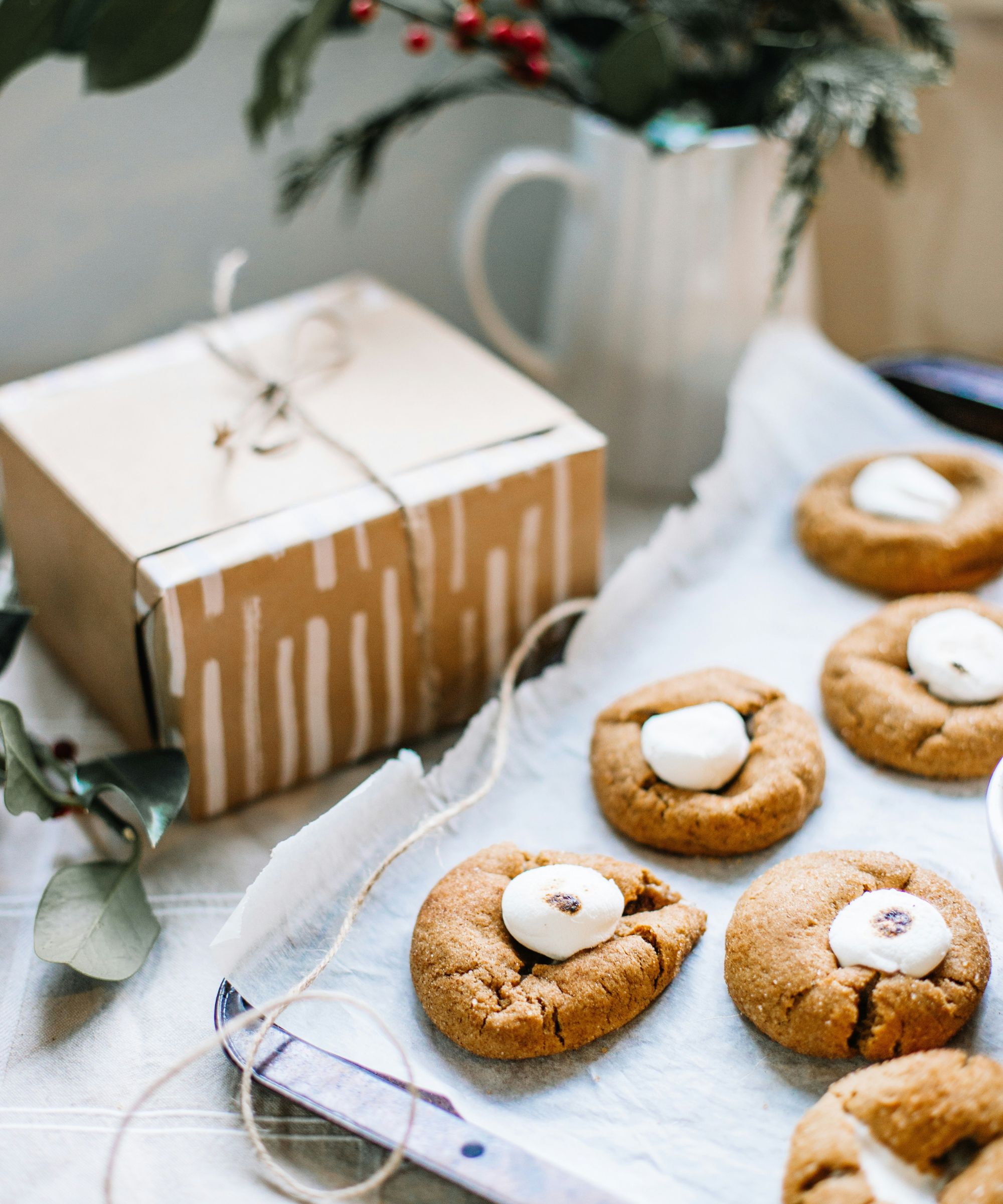 Cookies on a baking tray next to a brown card cookie box tied with string