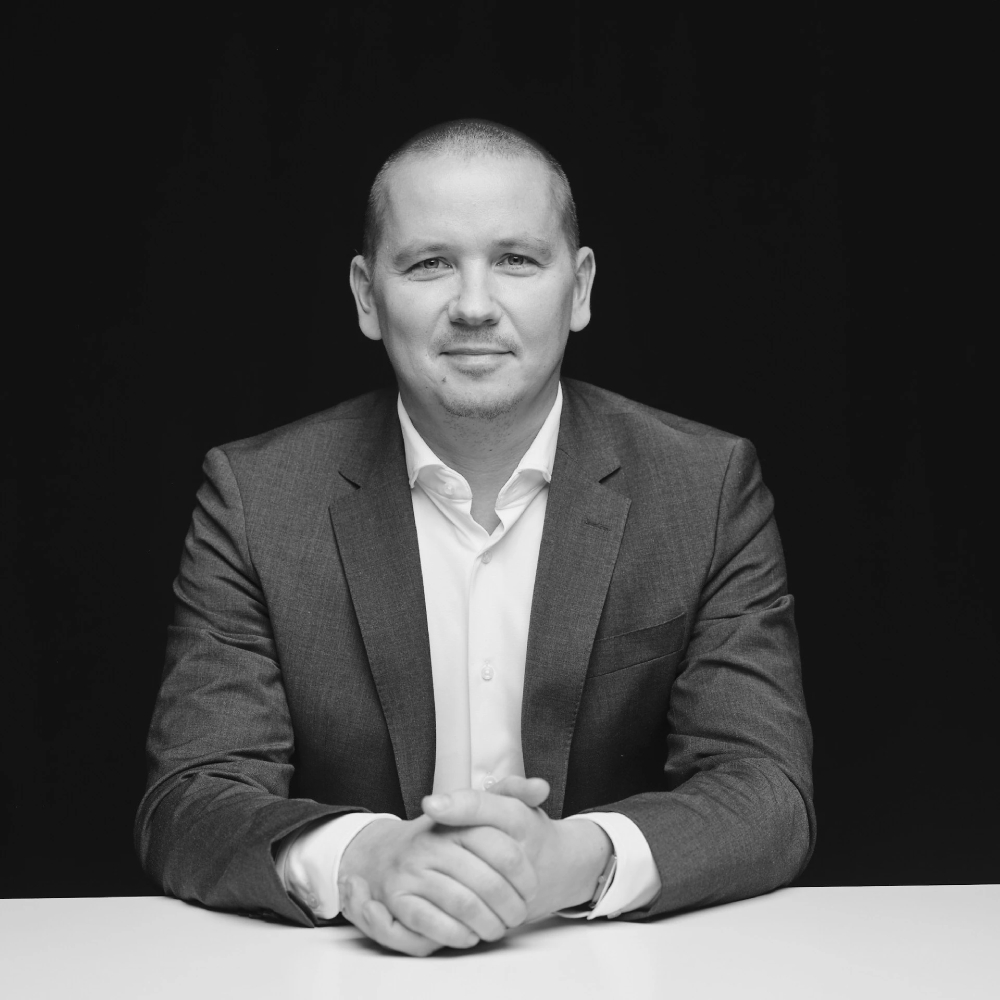 male sat at table wearing a suit jacket and shirt