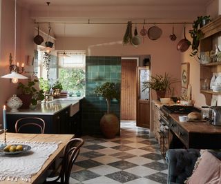 Pink kitchen walls paired with black and white chequerboard floor tiles