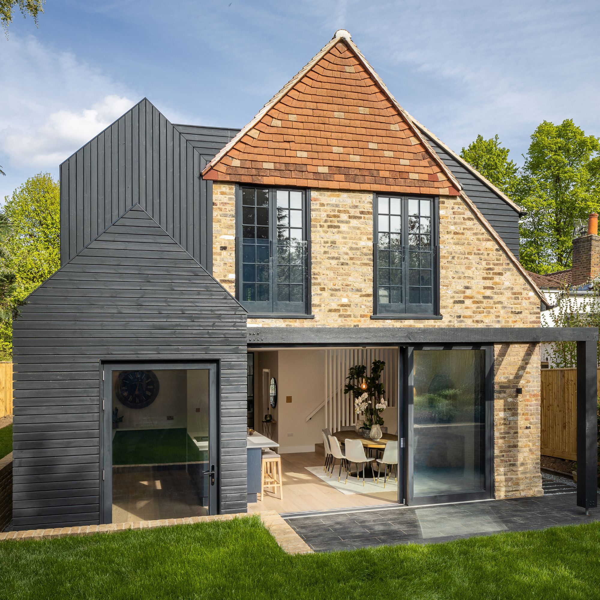 Black timber cladding on rear of brick home
