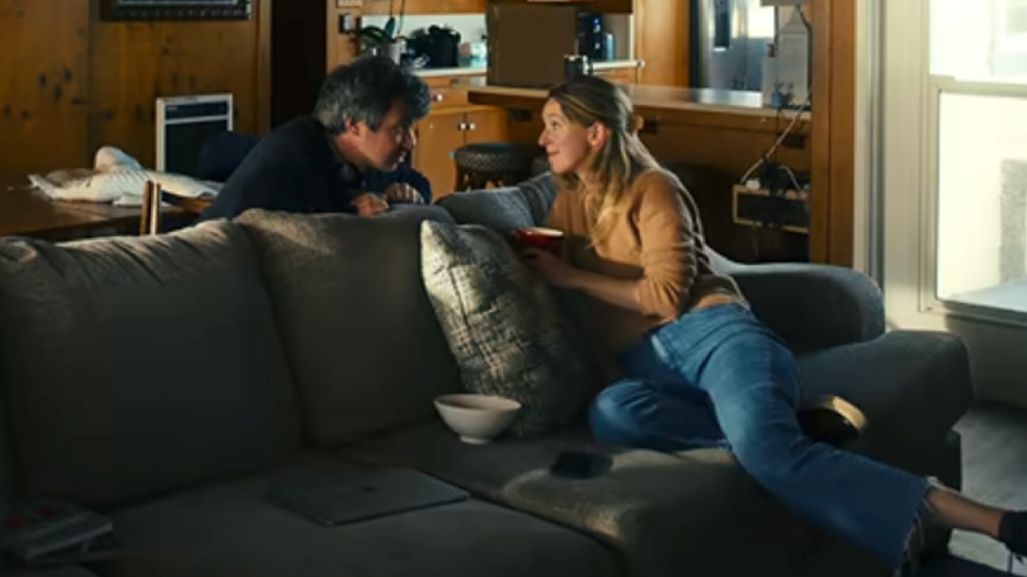 Elizabeth Holmes sitting on a coach, looking back at Nathan Fielder in You Can See Everything