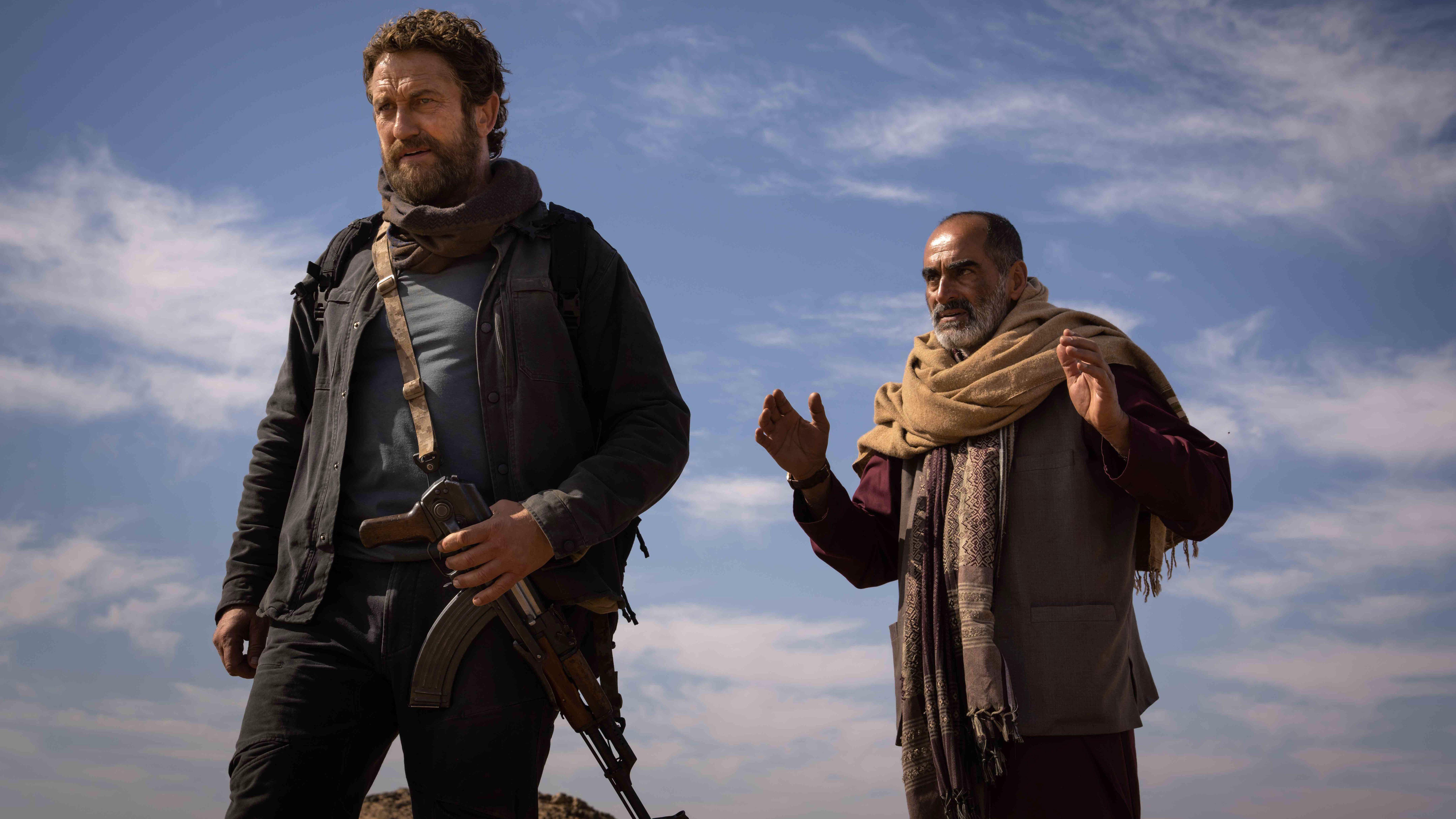L-R: Tom (Gerard Butler) and Mo (Navi Negahban) in a scene from "Kandahar" (2023)