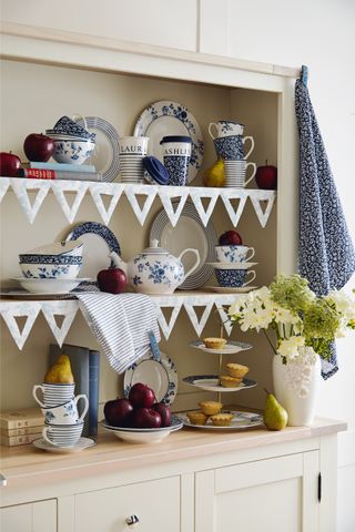 styling shelves: kitchen cabinet decorated with tea cups and bunting