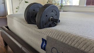 Testing the edge support of the Casper Original mattress using a 15lb dumbbell