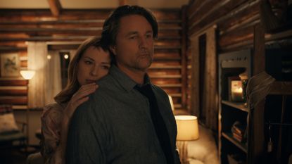 Alexandra Breckenridge as Mel Monroe, leaning on Martin Henderson as Jack Sheridan, while the pair stand in a log cabin&#039;s living room, in episode 602 of Virgin River.