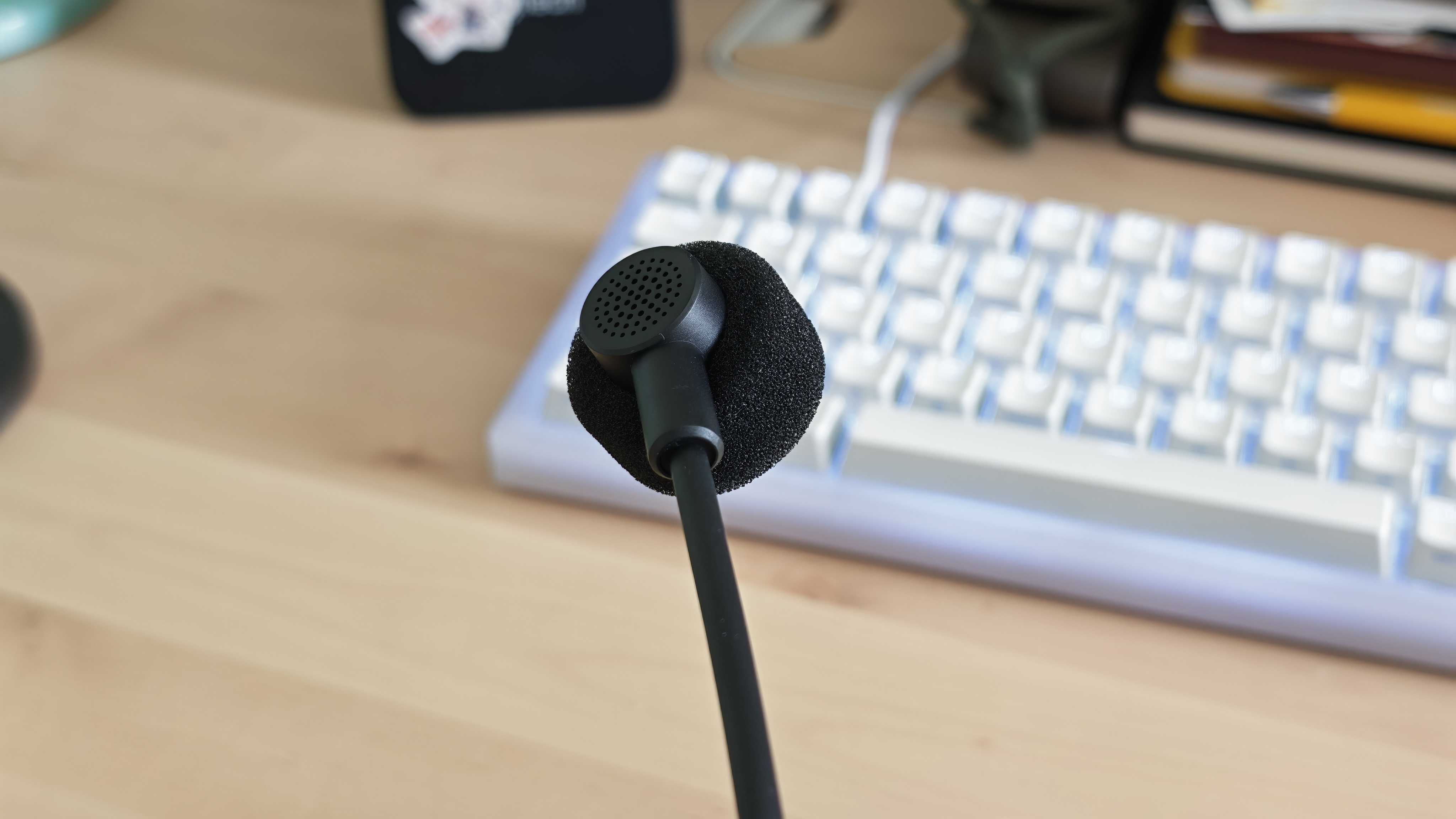 A photo of the Inzone H6 Air gaming headset positioned above a wooden desktop surface.