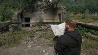 KCD2 - Henry looking at a map in front of a ruined house