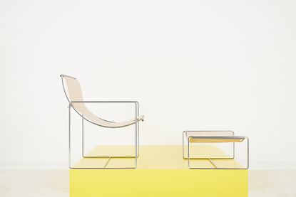 Chrome and natural leather 1970s lounge chair and ottoman shown on a yellow plinth, designed in the 1970s by Odile Mer and now reissued by LOMM Editions
