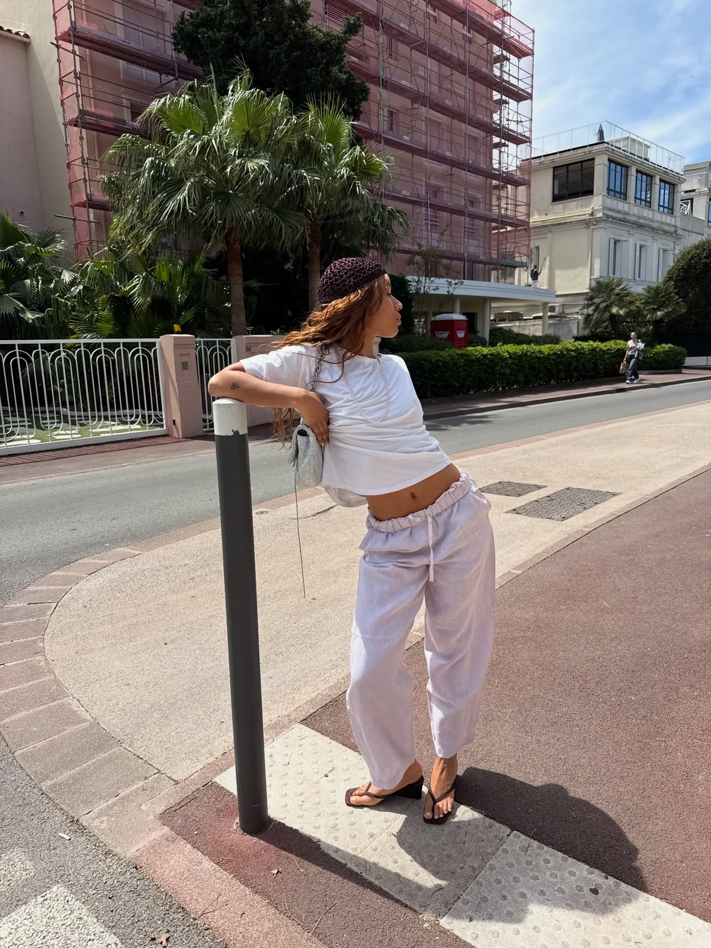 Woman in a t-shirt, linen pants, and wedges.