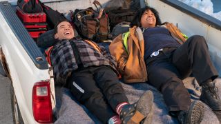 Conrad Ricamora and Natasha Rothwell lie laughing in the back of a truck in How To Die Alone