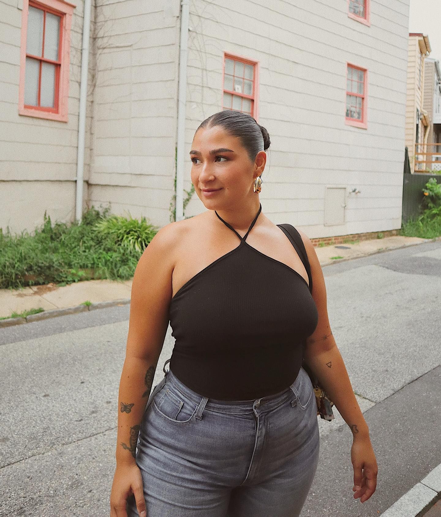 @javiera wears grey jeans with a black halter top