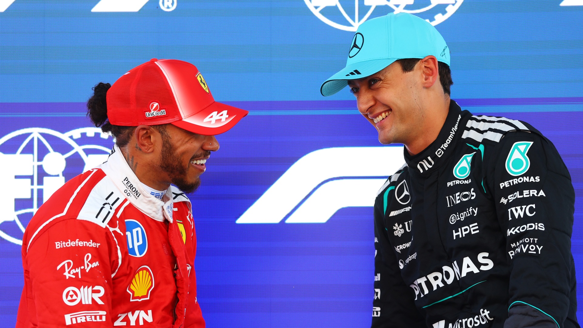 F1 drivers George Russell of Mercedes and Lewis Hamilton of Ferrari laughing together ahead of the 2026 Barcelona-Catalunya Grand Prix