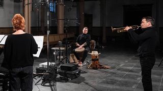 musicians in a hall playing the trumpet and drums