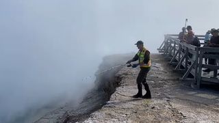 Park Ranger fishing for hats in geyser