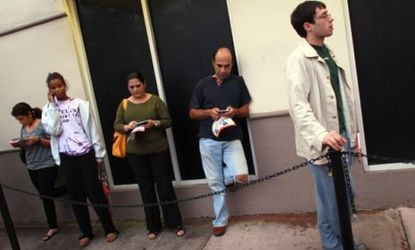 A small group of people wait outside a Verizon store in Florida to get their iPhones.