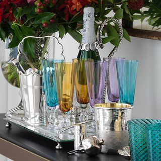 bottle of champagne with champagne flute and bar accessories