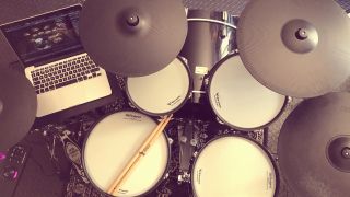 Overhead shot of electronic drum set plugged into a laptop running a VST