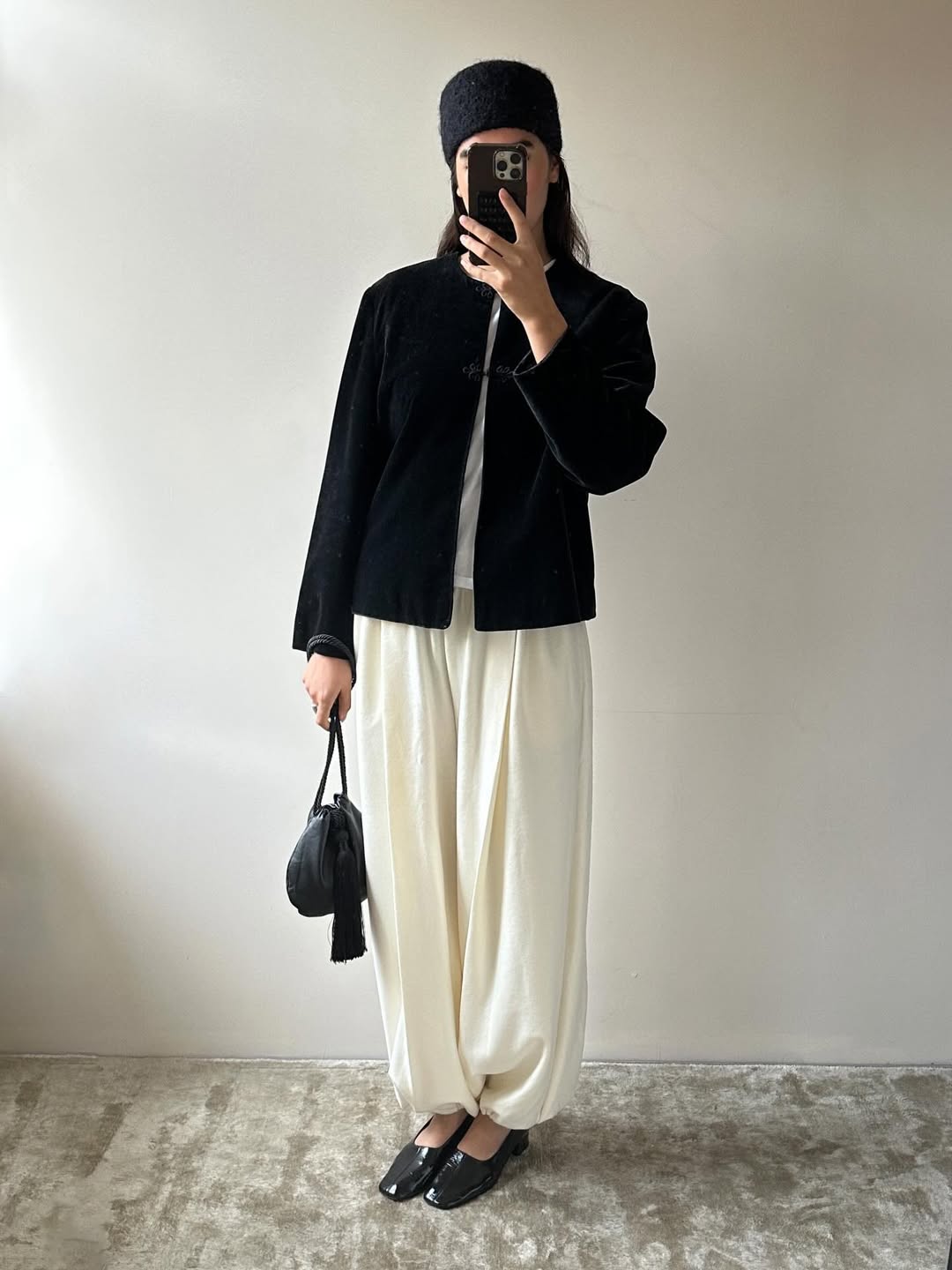 Selena Mual wearing a drawstring pouch tassel bag