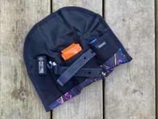 The distinctive orange of a Tubolito TPU inner tube poking out the top of a Wizard Works tool wrap, which is laid out on a wooden deck. 