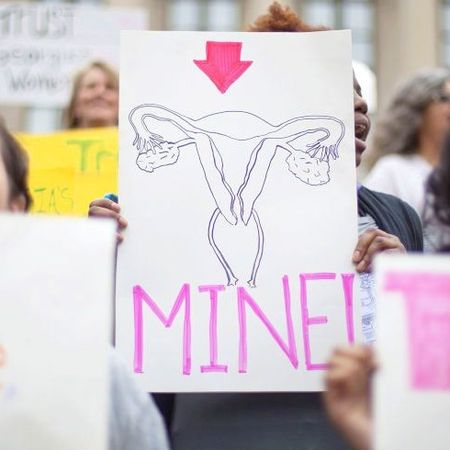 Woman holding self-made sign of fallopian tubes