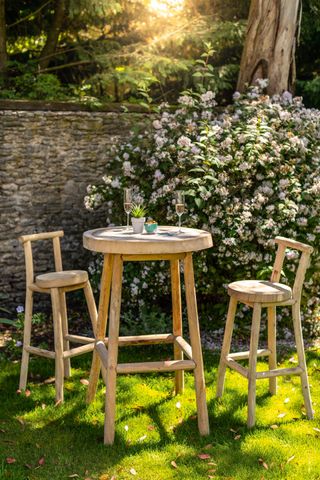 cottage patio ideas wooden bar table and stools in cottage garden