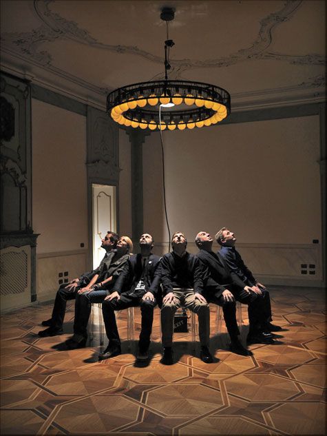 Men sitting on chairs in a circle looking upwards