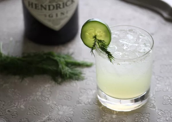 light-green cocktail in a tumbler with a bottle of Hendricks gin in the background