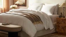 White bed with brown throw blanket