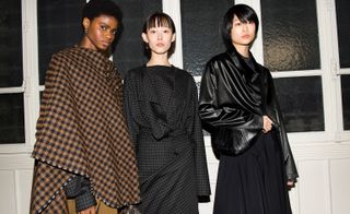 Models wear brown poncho, square patterned cotton shirt and matching skirt and leather blouse over black long skirt