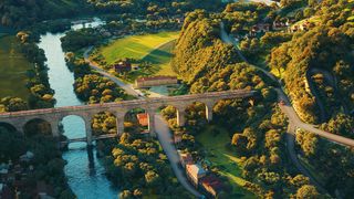 3ds Max 2024 review; a render of a train bridge in a leafy countryside setting