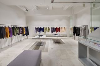 Inside Issey Miyake Ginza Tokyo store with rails of colourful clothes