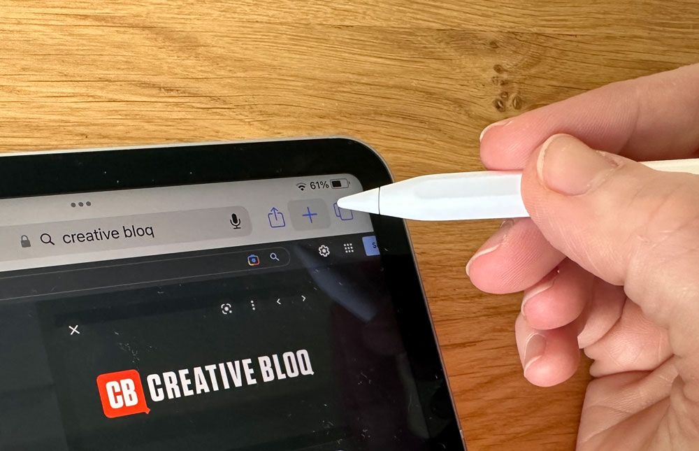 Hand holding Apple Pencil over iPad Pro