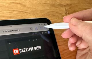 Hand holding Apple Pencil over iPad Pro