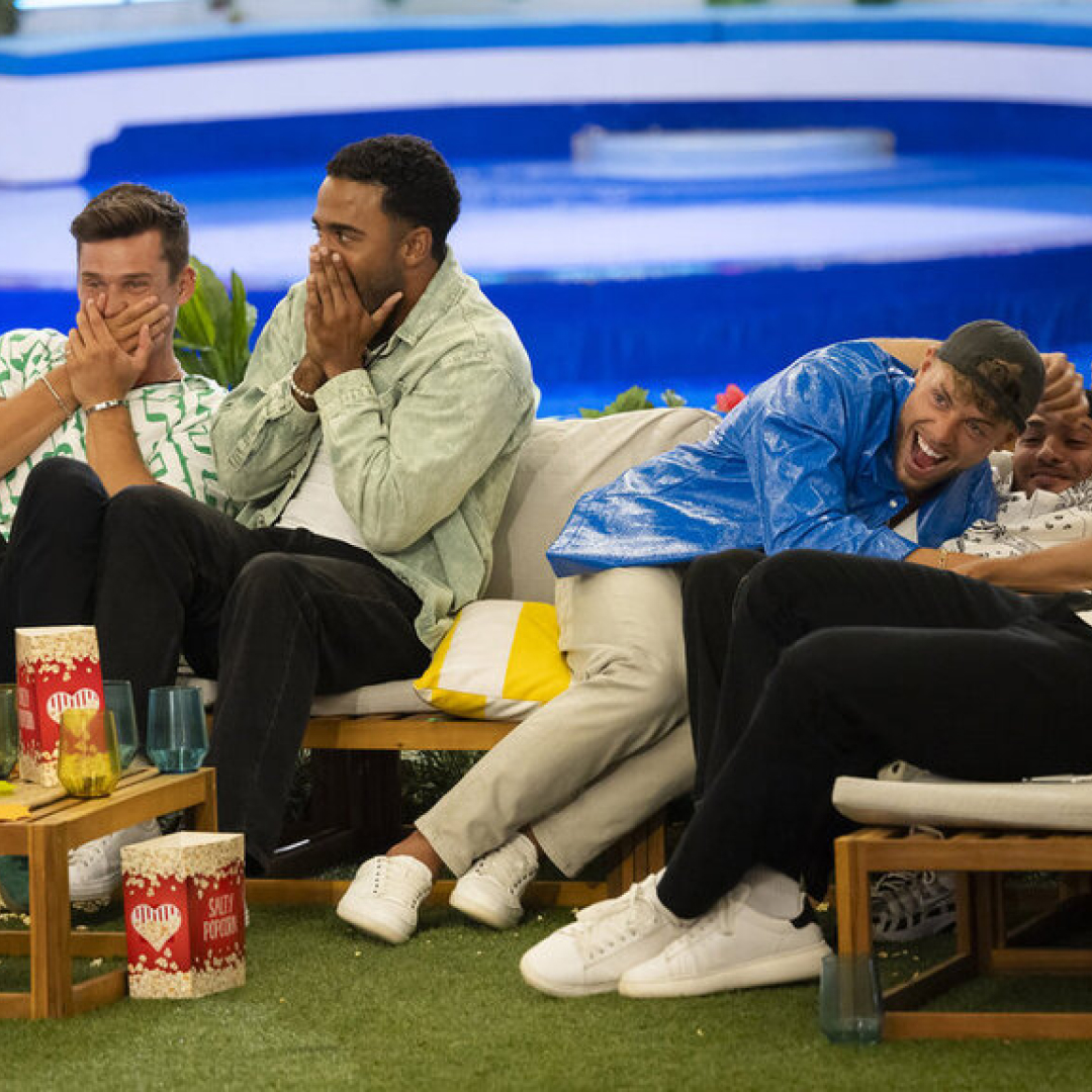 the men of love island usa season 6 laugh and looked shock covering their mouths while sitting on the couch and watching movie night