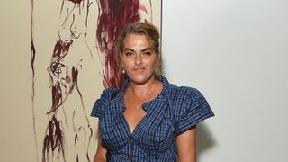 tracey emin standing in front of her art wearing a blue dress